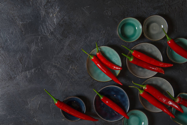 Red Hot Chili Peppers in bowls on old background - Фото, зображення