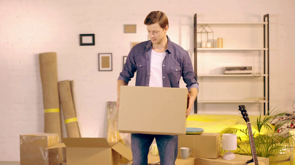 Nuori mies laittaa pahvilaatikon uuteen kotiin
 - Materiaali, video