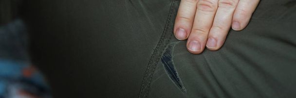 Hombre con piernas abiertas mostrando agujeros en los pantalones
 - Foto, Imagen