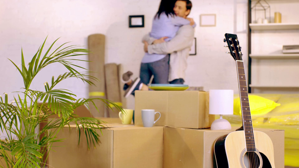 Ζευγάρι αγκαλιάζει κοντά σε κουτιά στο νέο σπίτι  - Πλάνα, βίντεο