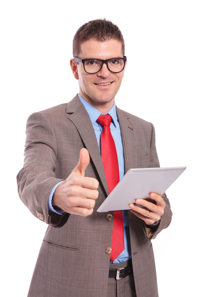 young business man holds tablet and shows thumb up - Photo, Image