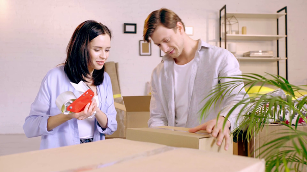 Jong stel verpakking dozen en lachen in de woonkamer - Video