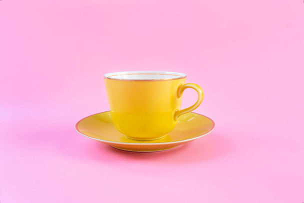 Pusty żółty kubek na różowym pastelowym tle. Żółty kubek pusty na kawę lub herbatę. koncepcja relaks - Zdjęcie, obraz
