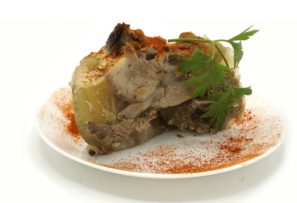 Traditionele Roemeense zelfgemaakte varkensvlees trotter gelei gerecht genaamd piftie. Jellied varkensvlees aspic gemaakt van varkensvlees geserveerd met paprika en verse peterselie. - Foto, afbeelding
