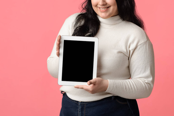 Цифровой планшет с черным экраном в руках неузнаваемой пухлой женщины
 - Фото, изображение