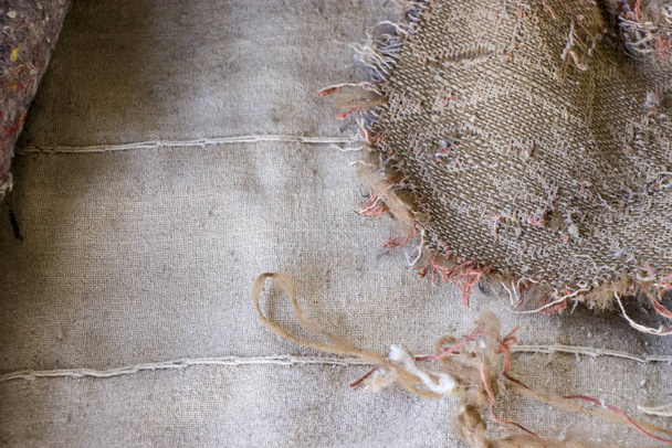 Old burlap and batting. Protruding threads. Conceptual background for design. - Photo, Image