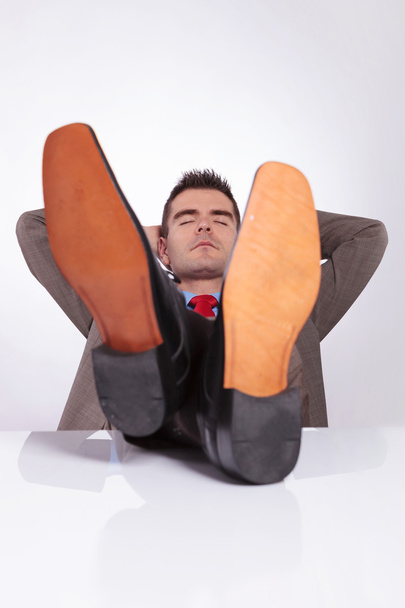 joven hombre de negocios duerme en la oficina con los pies en el escritorio
 - Foto, imagen