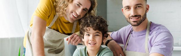 panoramatický záběr smíšené rasy dítě blízko šťastný homosexuální rodiče  - Fotografie, Obrázek