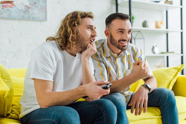 felici uomini omosessuali guardando la tv in soggiorno
  - Foto, immagini