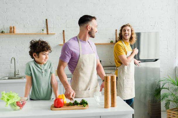 aranyos vegyes verseny gyerek közel boldog homoszexuális szülők a konyhában  - Fotó, kép