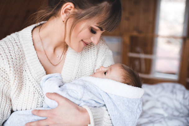 Smiling woman holding baby in room closeup. Motherhood. Maternity. 20s.  - Valokuva, kuva