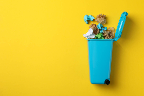 Ανακυκλώστε κάδο με σκουπίδια σε κίτρινο φόντο, χώρος για κείμενο - Φωτογραφία, εικόνα