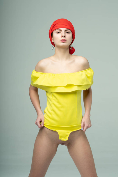 jovem menina bonita posando em um bodysuit amarelo
 - Foto, Imagem
