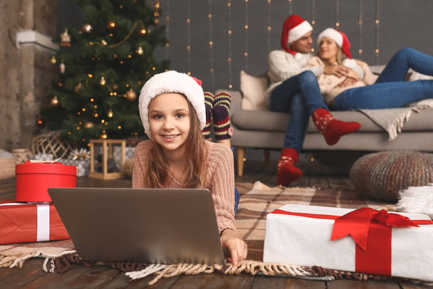 Little girl with laptop on Christmas eve at home - Photo, Image