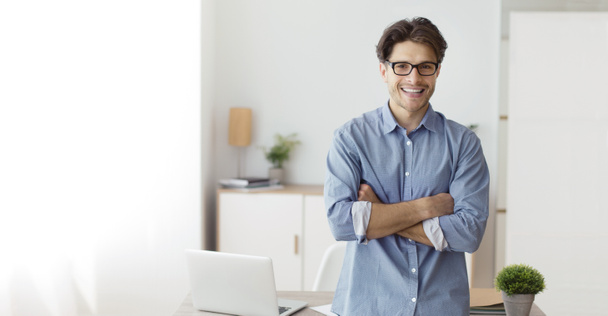 Freelancer confiante Guy Cruzando as mãos em pé no Home Office, Panorama
 - Foto, Imagem