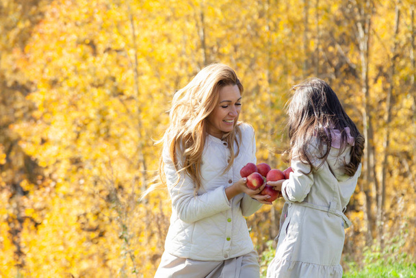 Feliz mamá y su hija en el parque de otoño
 - Foto, imagen