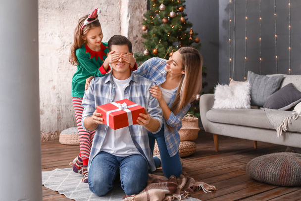 Żona i córka witają mężczyznę na Boże Narodzenie w domu - Zdjęcie, obraz