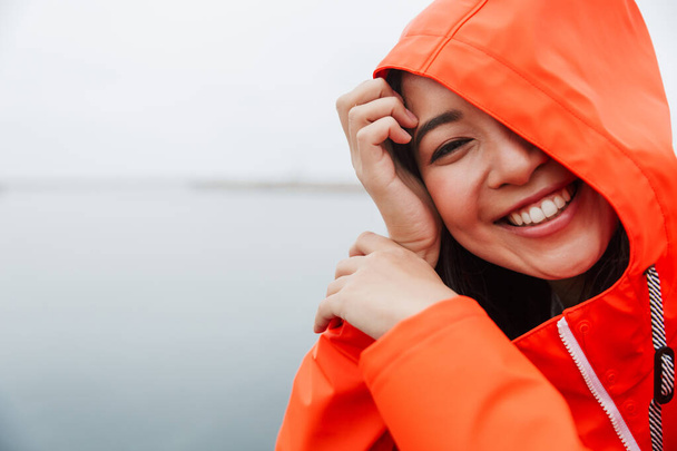 Smiling attractive young asian woman wearing raincoat - Photo, Image
