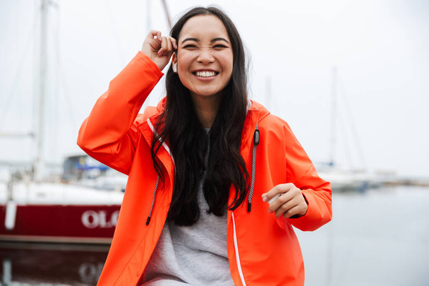 Smiling attractive young asian woman wearing raincoat - Foto, imagen