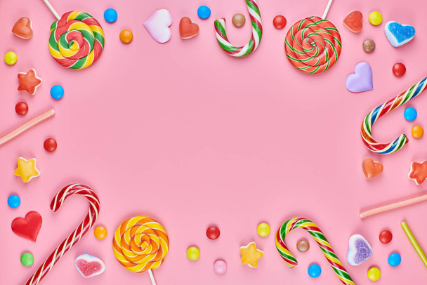 Sweet candy copy ruimte frame met lolly 's op roze achtergrond - Foto, afbeelding