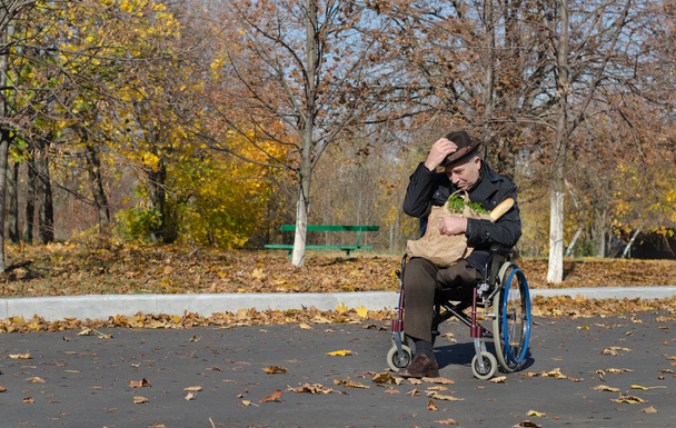 Yksinäinen vammainen mies pyörätuolissa
 - Valokuva, kuva