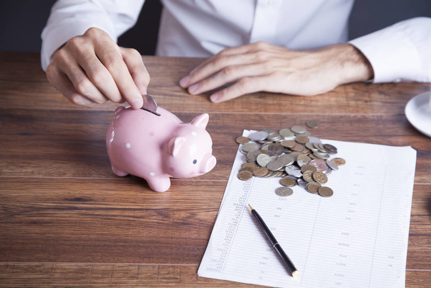 Man putting coin in piggy bank - Photo, Image