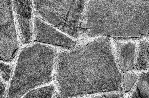 Parede de pedra fundo em preto e branco vista de perto
 - Foto, Imagem