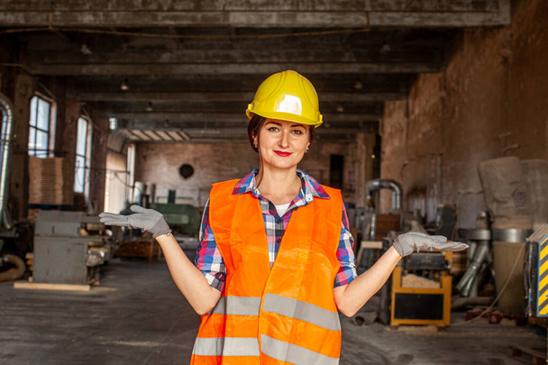 Charming woman in protective helmet welcoming to her working place - Фото, изображение