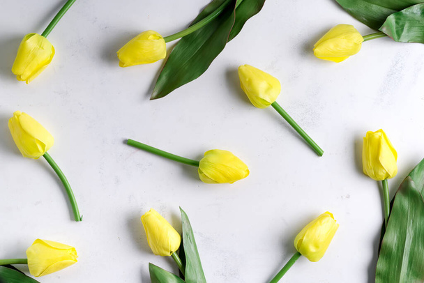 Sárga tulipánból készült virágminta márvány alapon. Lapos fekvés, csúcskilátás. Üdülési háttér. - Fotó, kép