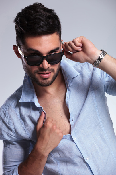 casual man pulls down sunglasses and opens shirt - Foto, Bild
