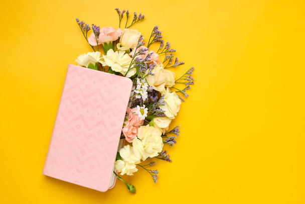 Pink Notepad with Flowers over yellow background. Spring mood - Valokuva, kuva