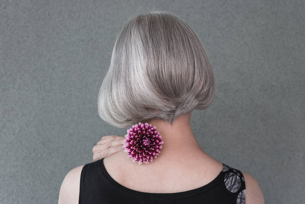Lady with beautiful silver hair and red dahlia - Photo, Image