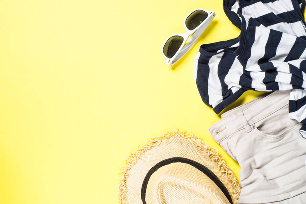 Sommer-Stoffset für Frauen - Hut, Oberteil, Shorts und Sonnenbrille auf gelb - Foto, Bild