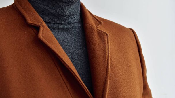 Close up van heren modieuze bruine wollen jas gecombineerd met grijze trui. Selectieve focus. - Foto, afbeelding