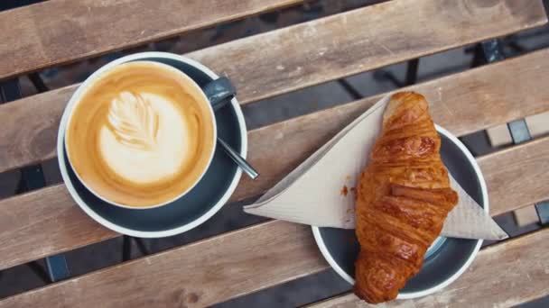 Сніданок з кавою і круасан на дерев'яному столі, крупним планом
 - Кадри, відео