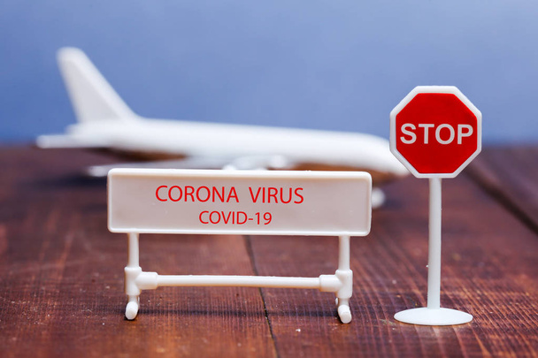 Señal de virus Corona en primer plano con avión de juguete en la parte posterior
 - Foto, Imagen