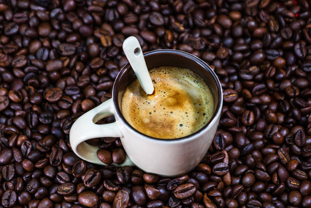 焙煎したコーヒー豆とコーヒーカップ赤を背景に、コーヒーc - 写真・画像