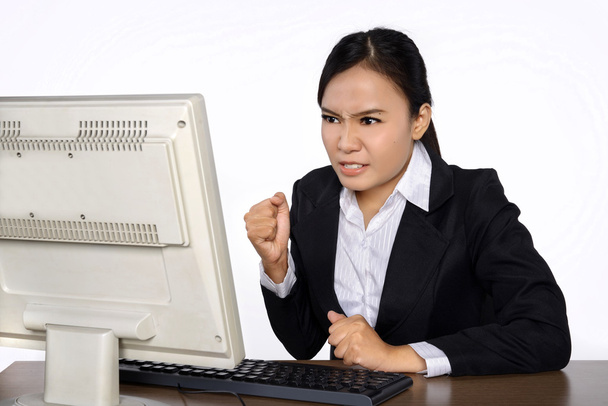 Бізнес-леді виглядає напруженою, коли вона працює на своєму комп'ютері
 - Фото, зображення