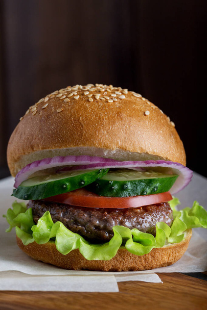 Close up burger with beef, green salad, cucumber, tomato and red onion - Fotografie, Obrázek