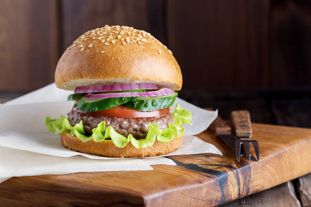 Fresh tasty burger on wooden background close up - Фото, изображение