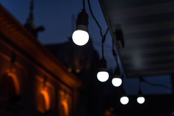 Ampoules anciennes suspendues dans un marché alimentaire de rue
. - Photo, image