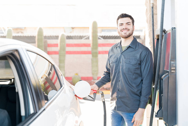 Fiducioso lavoratore maschile in uniforme auto di rifornimento al distributore di benzina
 - Foto, immagini