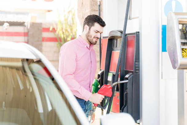 Mid adult man refueling vehicle at self-service gas station - Photo, Image