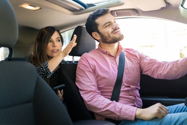 woman showing direction to confident male taxi driver - Fotó, kép