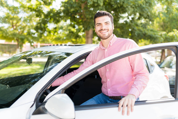 Hombre latino guapo en casuales abriendo la puerta de coche nuevo
 - Foto, imagen