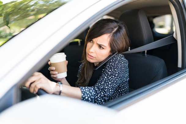 Mulher adulta média falando no telefone celular enquanto dirige o carro
 - Foto, Imagem