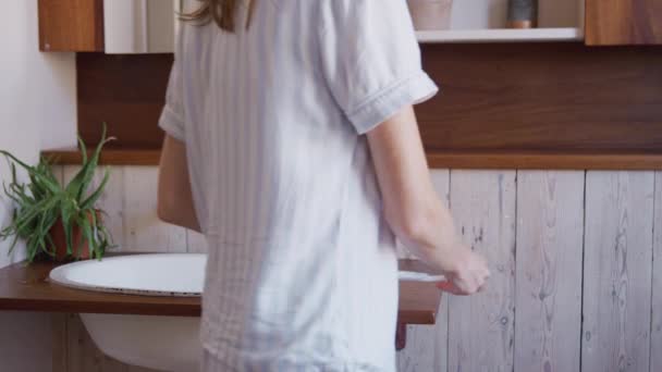 Worried woman looking at positive result pregnancy test in bathroom - shot in slow motion - Metraje, vídeo