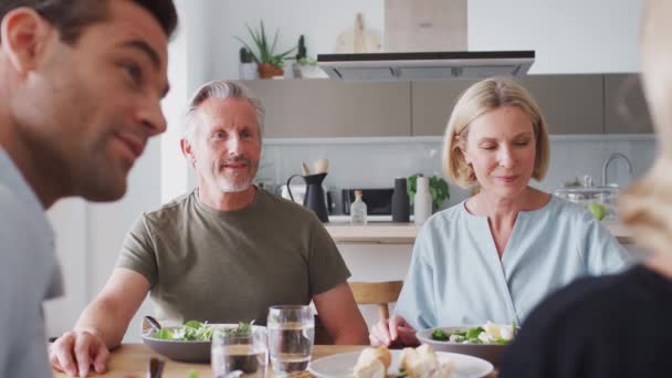 Family with senior parents and adult offspring sitting around table at home enjoying meal together - shot in slow motion - Filmmaterial, Video