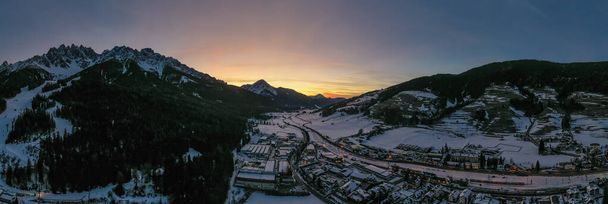 San Candido Innichen nocą w południowym Tyrolu Alto Adige we Włoszech w sezonie zimowym. Zdjęcie panoramiczne drona lotniczego w styczniu 2020 roku - Zdjęcie, obraz