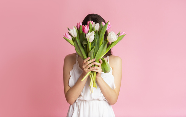 Unrecognizable Girl Covering Her Face With Bouquet Of Tulips - Fotó, kép
